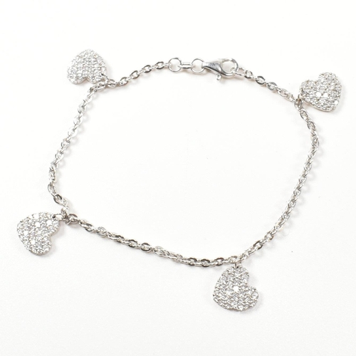 398 - A hallmarked 9ct white gold and CZ heart charm bracelet. The cable link chain bracelet having four C... 