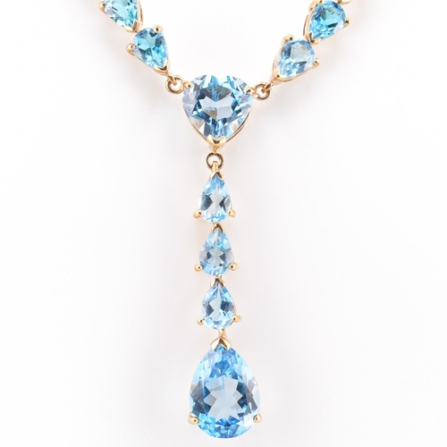 46 - A hallmarked 9ct gold and Swiss blue topaz pendant necklace. The 9ct yellow gold lariat necklace set... 