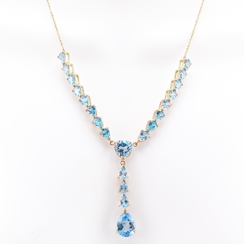 46 - A hallmarked 9ct gold and Swiss blue topaz pendant necklace. The 9ct yellow gold lariat necklace set... 