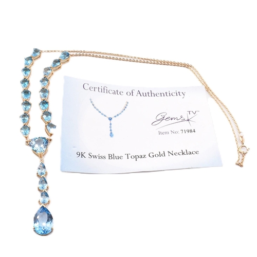 46 - A hallmarked 9ct gold and Swiss blue topaz pendant necklace. The 9ct yellow gold lariat necklace set... 