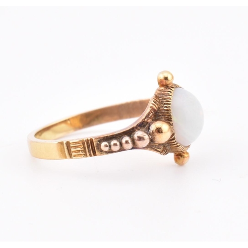 58 - A Victorian opal ring. The antique ring having a single round collet set opal cabochon set in a deco... 