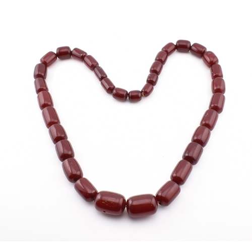 70 - A vintage cherry amber Bakelite bead necklace. The vintage cherry bakelite necklace strung with thir... 