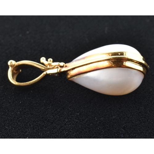 76 - A hallmarked 18ct gold, mabe pearl and diamond necklace pendant. The 18ct yellow gold necklace penda... 