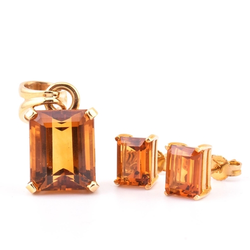 92 - An 18ct gold and citrine pendant and earring suite. The pendant having a claw mounted emerald cut ci... 