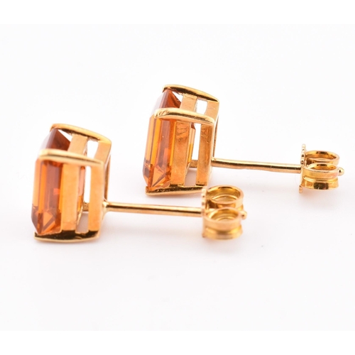 92 - An 18ct gold and citrine pendant and earring suite. The pendant having a claw mounted emerald cut ci... 