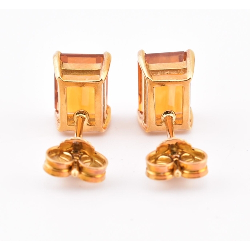 92 - An 18ct gold and citrine pendant and earring suite. The pendant having a claw mounted emerald cut ci... 