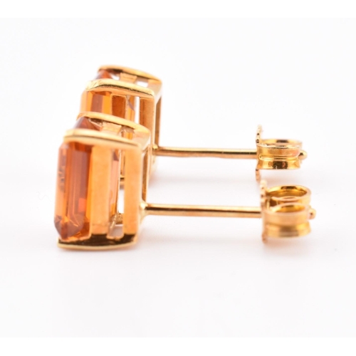 92 - An 18ct gold and citrine pendant and earring suite. The pendant having a claw mounted emerald cut ci... 