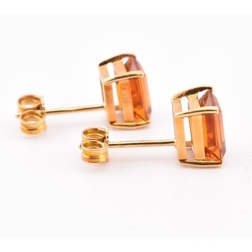 92 - An 18ct gold and citrine pendant and earring suite. The pendant having a claw mounted emerald cut ci... 