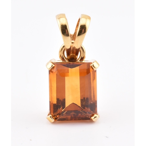 92 - An 18ct gold and citrine pendant and earring suite. The pendant having a claw mounted emerald cut ci... 