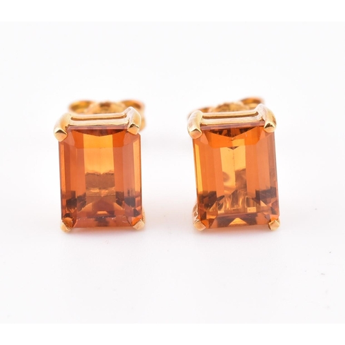 92 - An 18ct gold and citrine pendant and earring suite. The pendant having a claw mounted emerald cut ci... 