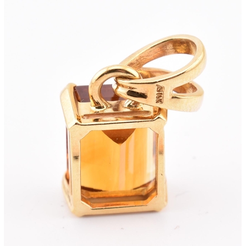 92 - An 18ct gold and citrine pendant and earring suite. The pendant having a claw mounted emerald cut ci... 