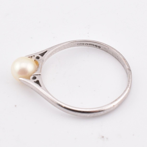 99 - A hallmarked 18ct gold and pearl ring. The 18ct white gold ring set with a single round pearl to che... 