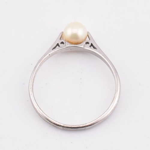 99 - A hallmarked 18ct gold and pearl ring. The 18ct white gold ring set with a single round pearl to che... 