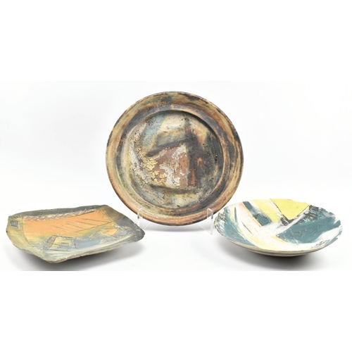 174 - A selection of 20th century studio art pottery charger plates. Each charger being hand-painted and m... 