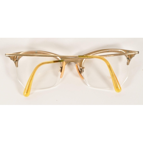 209 - Goldray - A mid 20th century pair of cat eye reading glasses. Having a gilt frame and arms, frameles... 