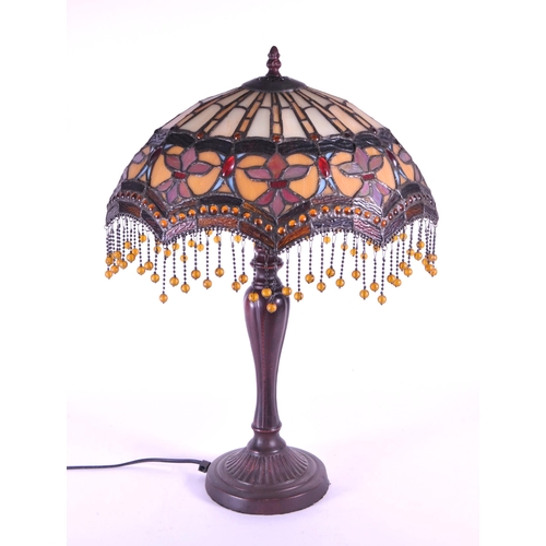 250 - 20th century Tiffany style table lamp featuring an oval glass shade. The lamp featuring a plinth sty... 