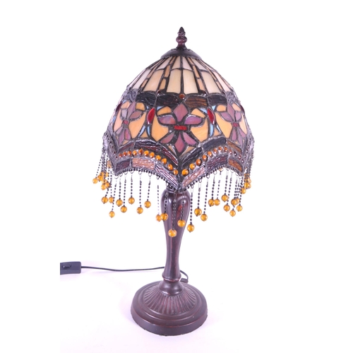 250 - 20th century Tiffany style table lamp featuring an oval glass shade. The lamp featuring a plinth sty... 