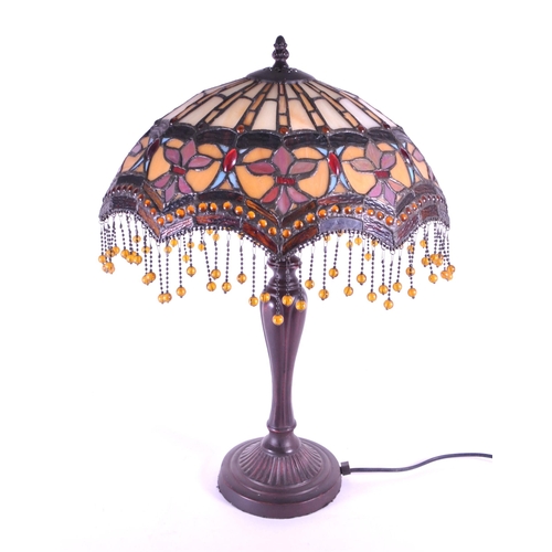 250 - 20th century Tiffany style table lamp featuring an oval glass shade. The lamp featuring a plinth sty... 