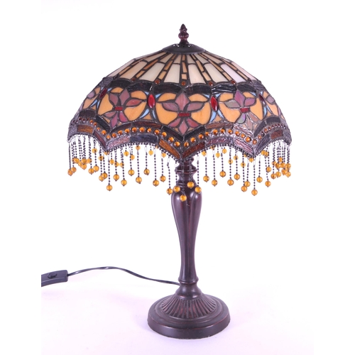 256 - A 20th century Tiffany style table lamp. The lamp featuring a plinth style base with fluted gadroone... 