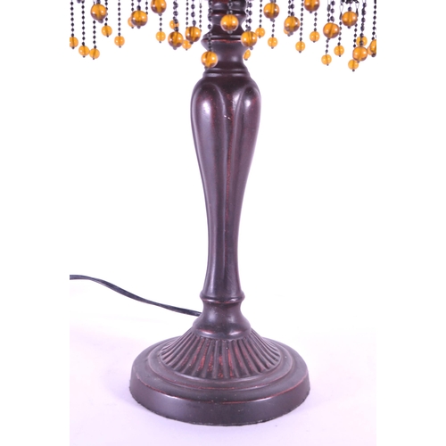 256 - A 20th century Tiffany style table lamp. The lamp featuring a plinth style base with fluted gadroone... 