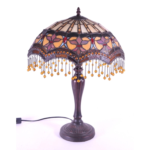 260 - A 20th century Tiffany style table lamp. The lamp featuring a plinth style base with fluted gadroone... 