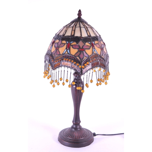 260 - A 20th century Tiffany style table lamp. The lamp featuring a plinth style base with fluted gadroone... 