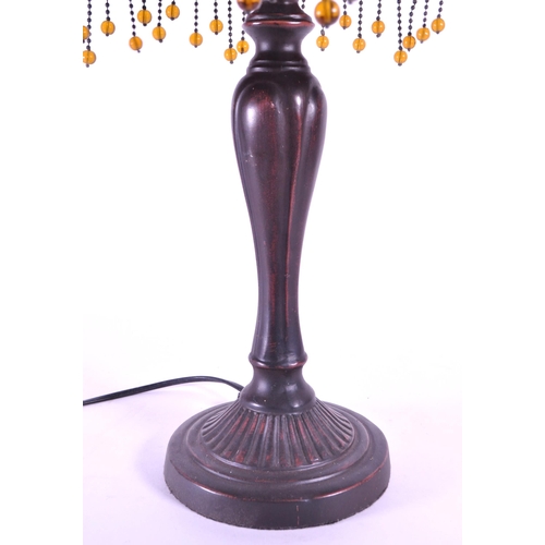 260 - A 20th century Tiffany style table lamp. The lamp featuring a plinth style base with fluted gadroone... 