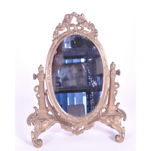264 - A vintage 20th century gilt tabletop swing mirror. Neoclassical French style on scrolled foliate tre... 
