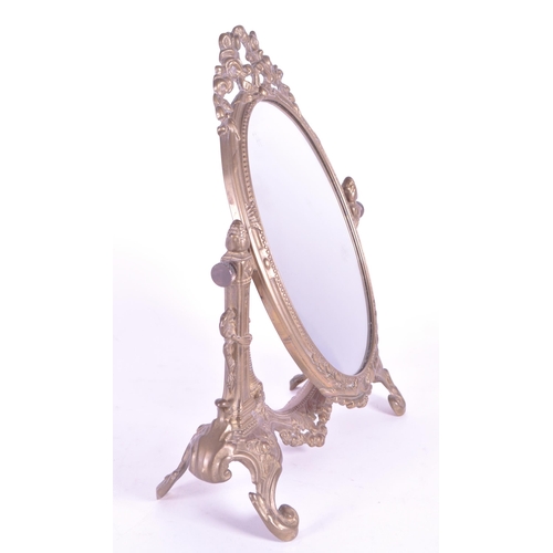 264 - A vintage 20th century gilt tabletop swing mirror. Neoclassical French style on scrolled foliate tre... 