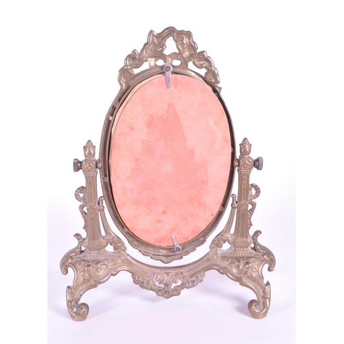 264 - A vintage 20th century gilt tabletop swing mirror. Neoclassical French style on scrolled foliate tre... 