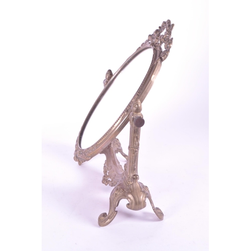 264 - A vintage 20th century gilt tabletop swing mirror. Neoclassical French style on scrolled foliate tre... 