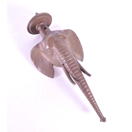 267 - A vintage 20th century brass door knocker in African elephant form. With long trunk, tusks and circu... 