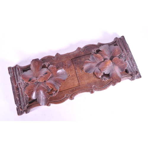268 - A late 19th century black forest German adjustable book slide. With carved leaves to ends, adjustabl... 