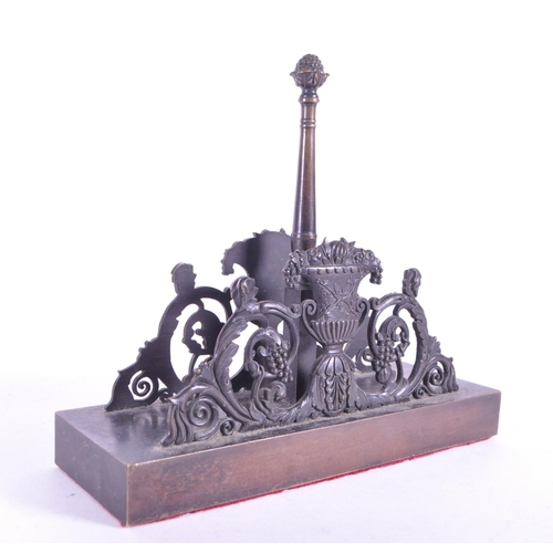 270 - A 19th century bronze letter magazine rack / desk tidy. Neoclassical design with acorn finial to cen... 