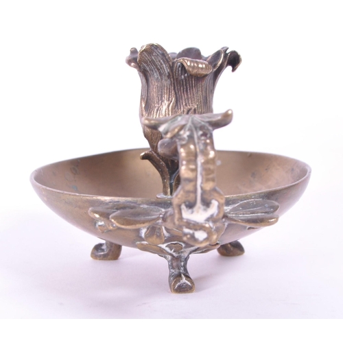 294 - A 19th century Art Nouveau brass candle holder / chamberstick. Foliate carry handle with bowl wax ru... 