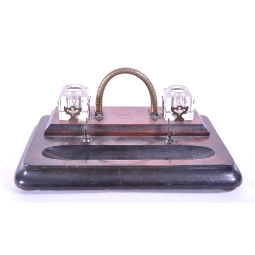 299 - An early 20th mahogany office desk tidy / ink well. With brass carry handle, two cut glass ink wells... 