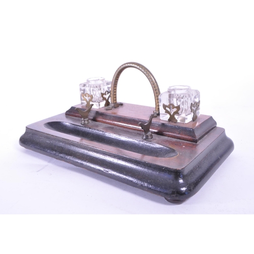 299 - An early 20th mahogany office desk tidy / ink well. With brass carry handle, two cut glass ink wells... 