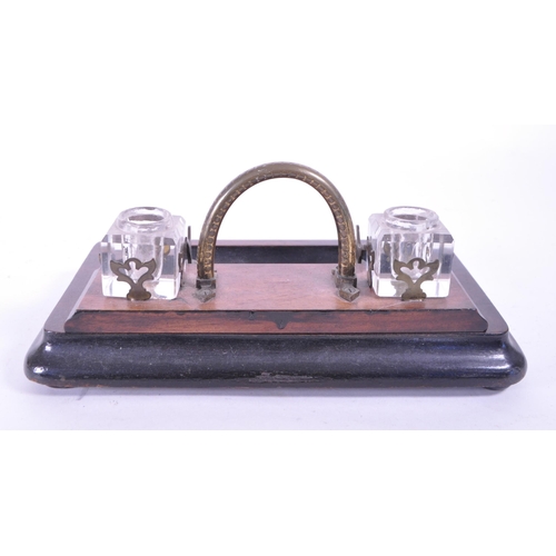 299 - An early 20th mahogany office desk tidy / ink well. With brass carry handle, two cut glass ink wells... 