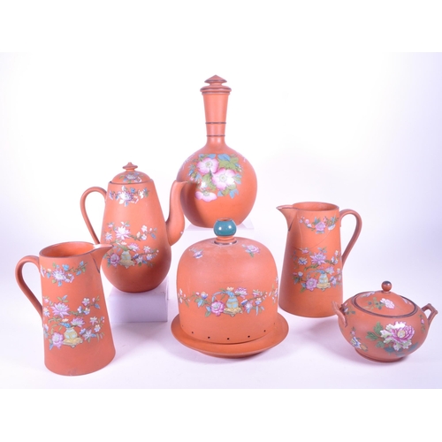 385 - A collection of 19th century Rosso Antico tableware items. To include cloche, water jugs, teapot, tw... 