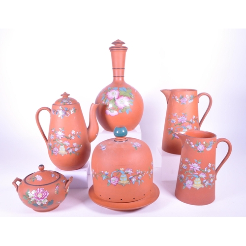 385 - A collection of 19th century Rosso Antico tableware items. To include cloche, water jugs, teapot, tw... 
