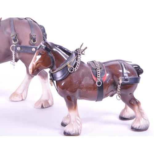 413 - Beswick - Two china porcelain horse figurines. Including Clydesdale Shire horse 2465 in working harn... 