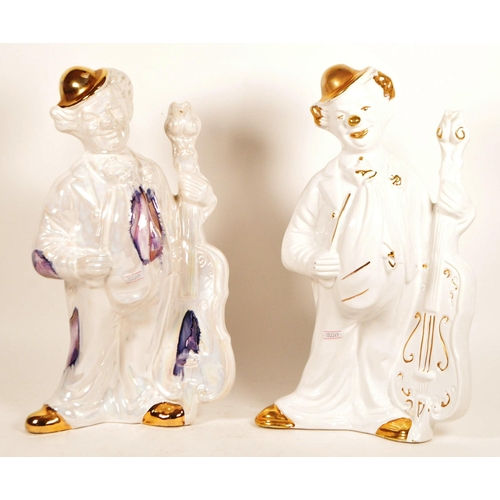 171 - Two large late 20th century ceramic white and gilt clown figures. Both depicted holding a cello, one... 