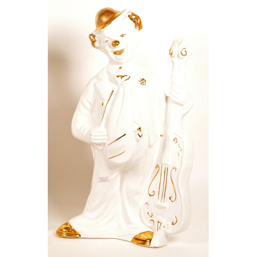 171 - Two large late 20th century ceramic white and gilt clown figures. Both depicted holding a cello, one... 
