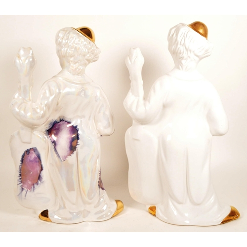 171 - Two large late 20th century ceramic white and gilt clown figures. Both depicted holding a cello, one... 