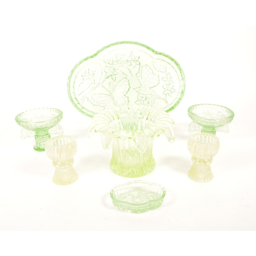 126 - A collection of mid 20th century vaseline glass decorative items. The collection to include candlest... 