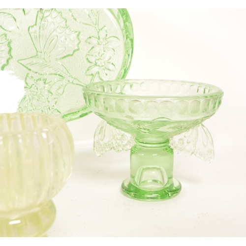 126 - A collection of mid 20th century vaseline glass decorative items. The collection to include candlest... 