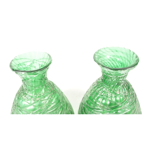 56 - Manner of Loetz - Two 20th century art nouveau style green glass vases / bottles. Featuring a strapp... 