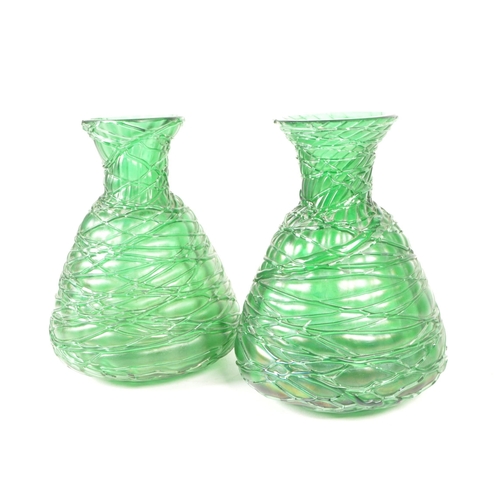 56 - Manner of Loetz - Two 20th century art nouveau style green glass vases / bottles. Featuring a strapp... 