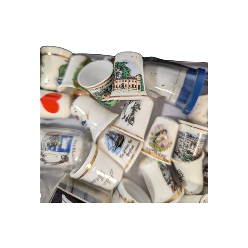 136 - A collection of 20th century commemorative souvenir bone china thimbles. The collection including ex... 