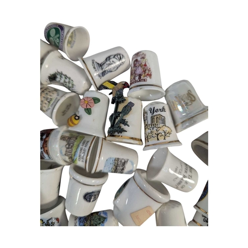 136 - A collection of 20th century commemorative souvenir bone china thimbles. The collection including ex... 